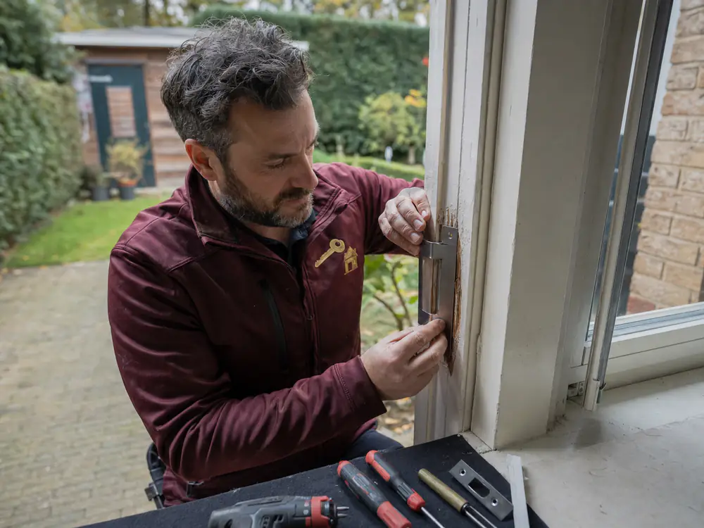 Slotenmaker herstelt inbraakschade aan een houten kozijn en plaatst nieuw sluitwerk